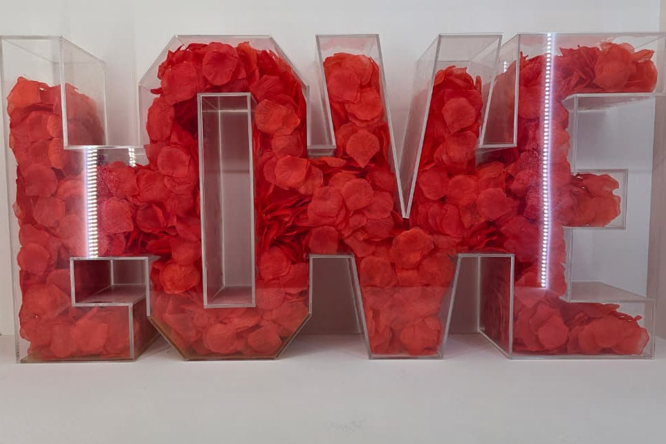 Decorative letters spelling 'LOVE' filled with red rose petals.