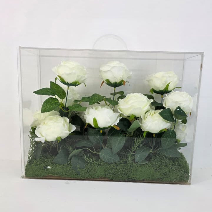 Clear box with white artificial flowers on a white background